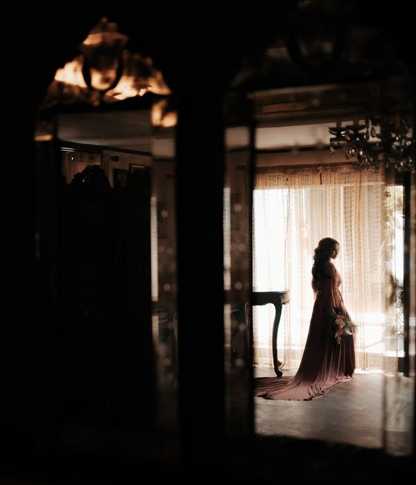 Woman in a graceful pose in a dark room with amber light.